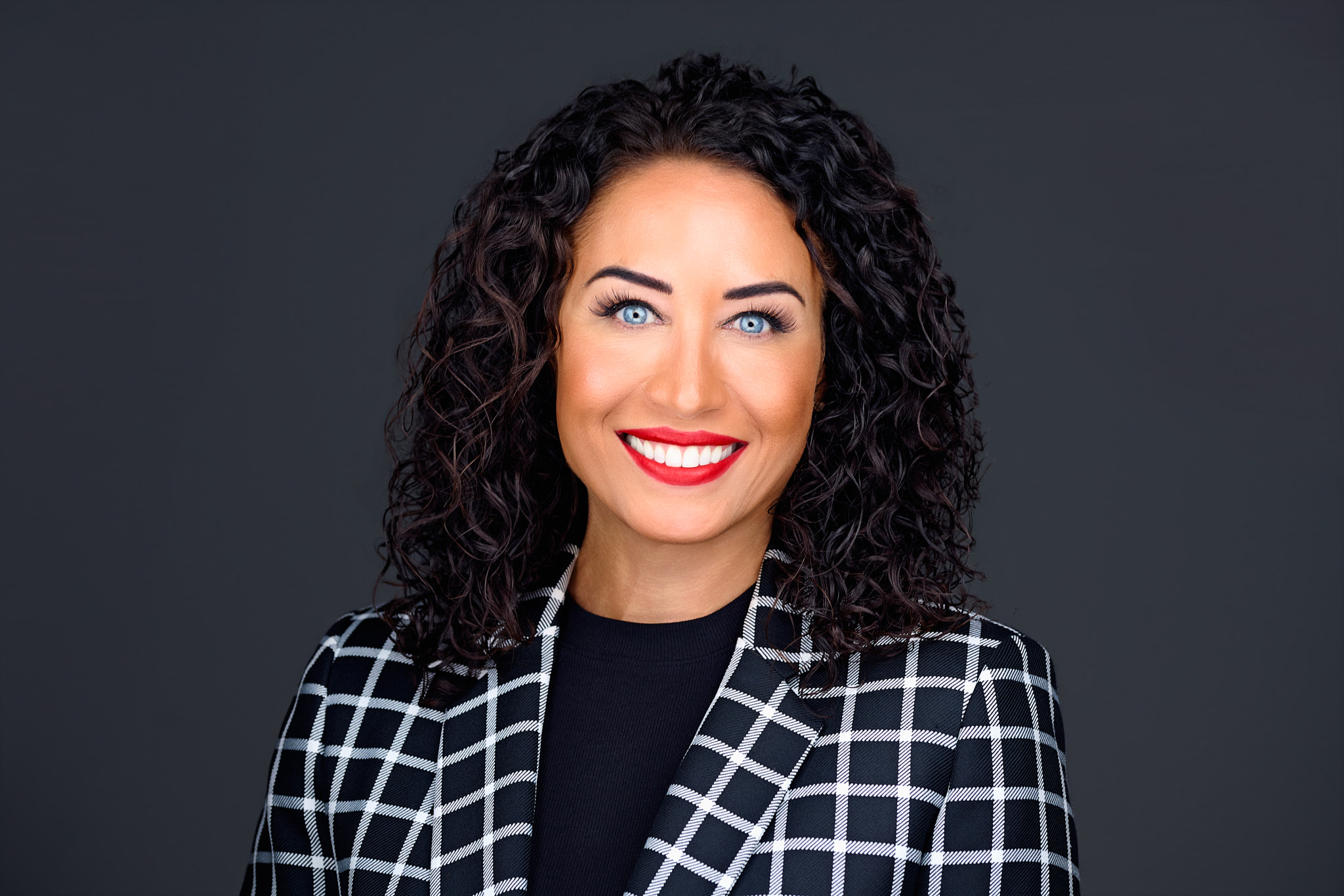 Dr. Tara Chalakani smiling in a windowpane blazer